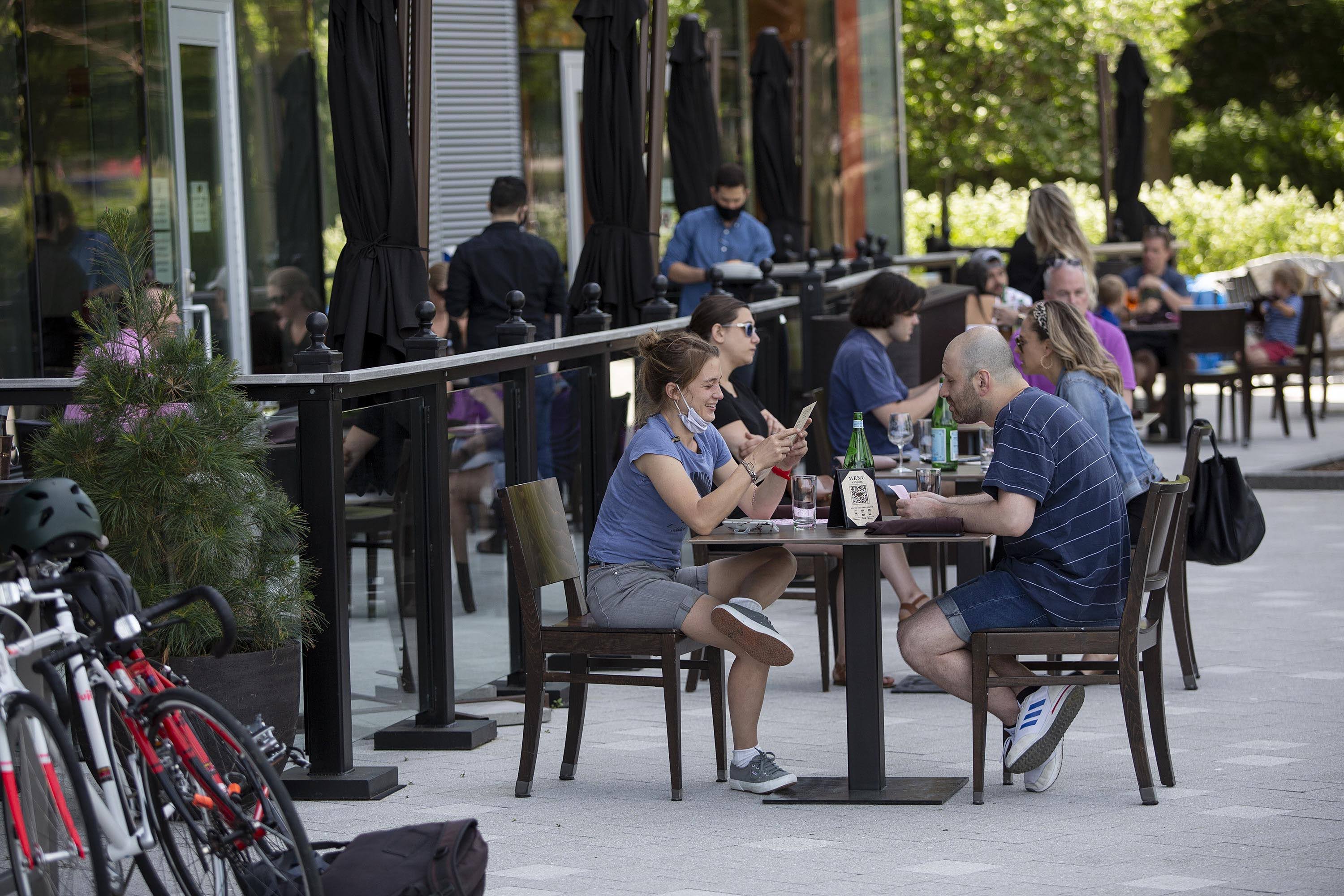 Guests eating outside at Lola 42, with a view of the harbor. (Robin Lubbock/WBUR)