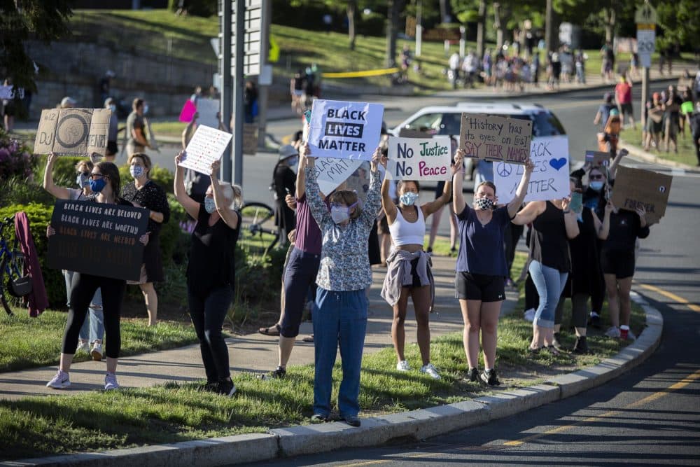 West Roxbury protesters at the Vigil For Black Lives line the Centre Street traffic circle, and the roads leading off it, waving signs and chanting. (Robin Lubbock/WBUR)