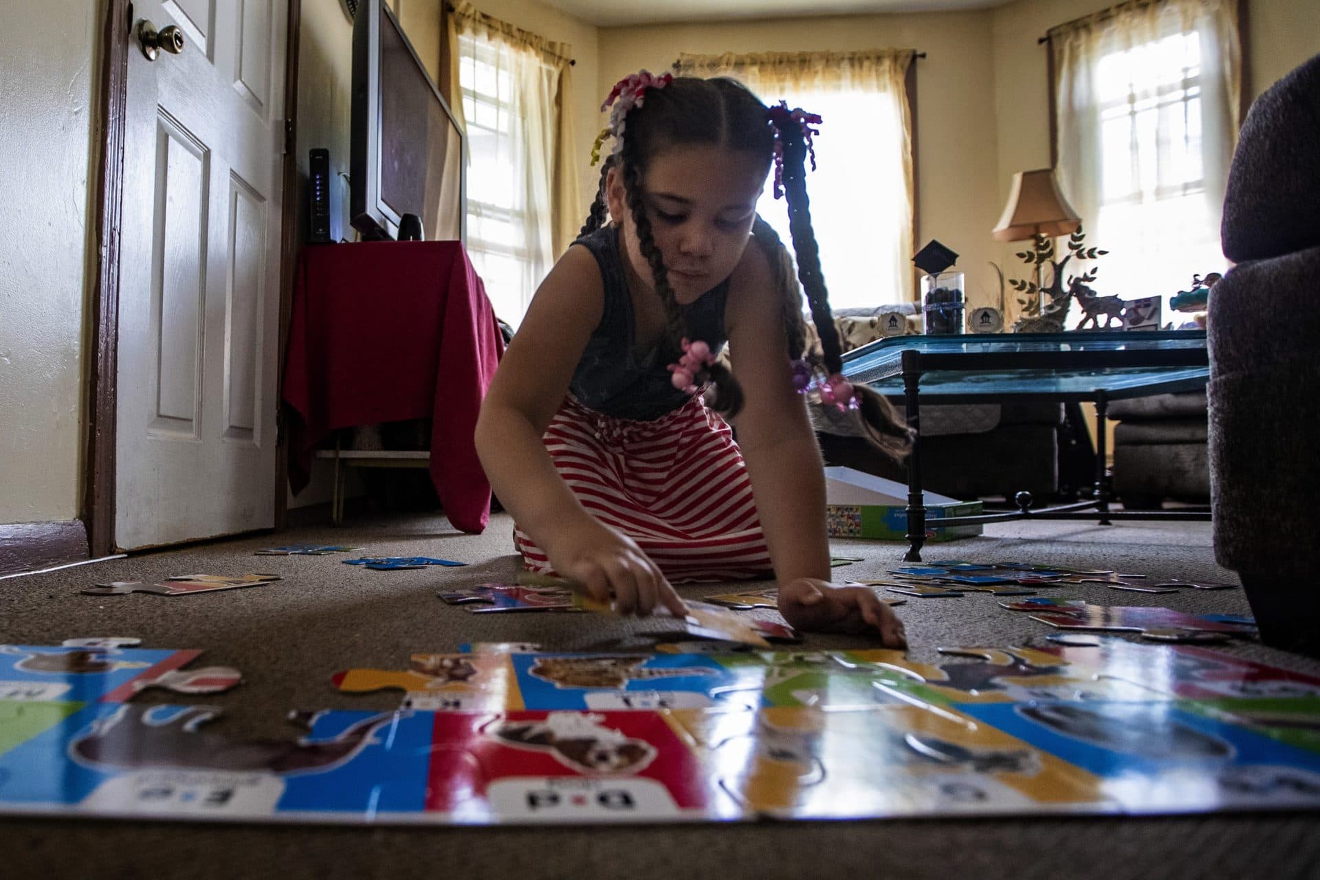 Luz works on a puzzle with animals and the letters of the alphabet. (Jesse Costa/WBUR)