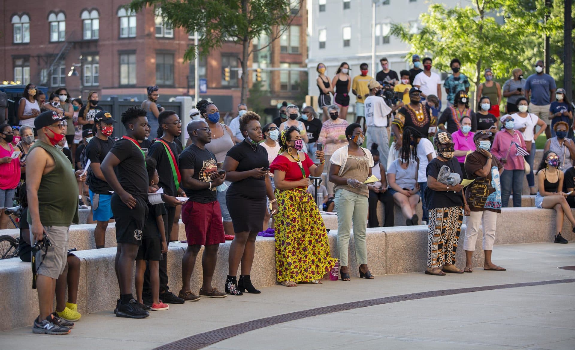 The Juneteenth gathering at Brockton City Hall stands to sing the Black National Anthem. (Robin Lubbock/WBUR)