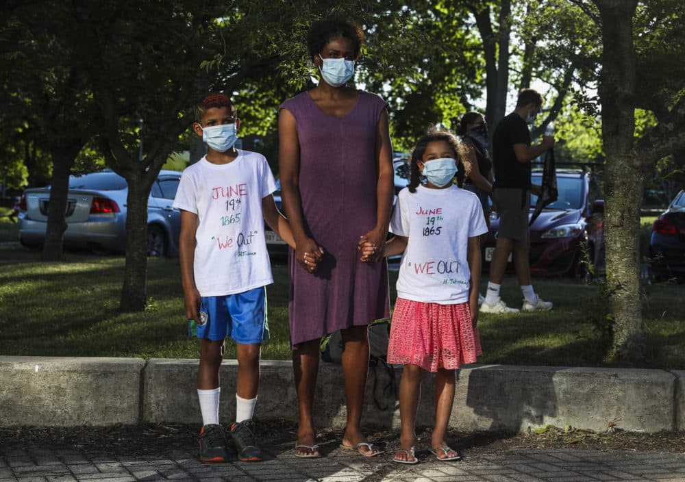 Teronda Ellis stands with her children Finn, 9, left, and Soling, 7, before they march in a Juneteenth Awareness Walk that began at the Boys & Girls Club and walked to Franklin Park in Dorchester. (Erin Clark/The Boston Globe via Getty Images)