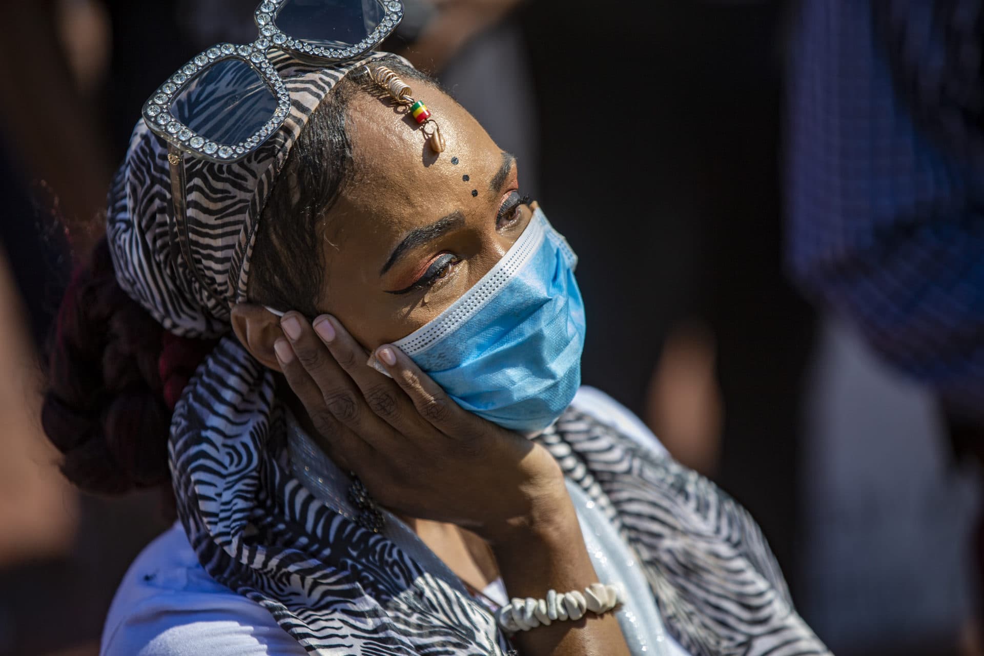 A woman cries while Monica Cannon-Grant speaks to those gathered in front of the State House. (Jesse Costa/WBUR)