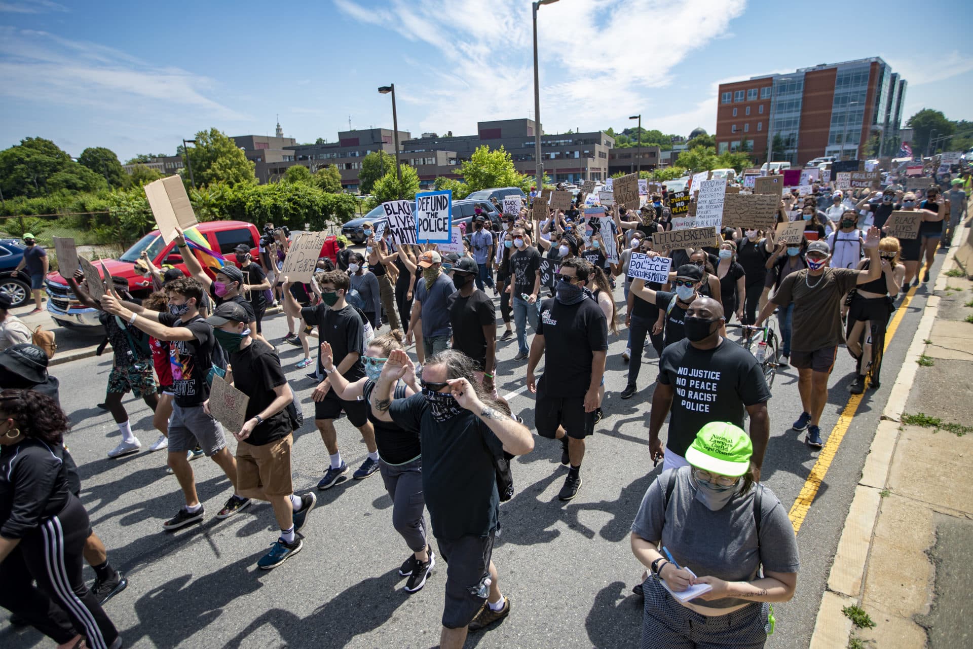 Protesters march past the Boston Police Headquarters. (Jesse Costa/WBUR)