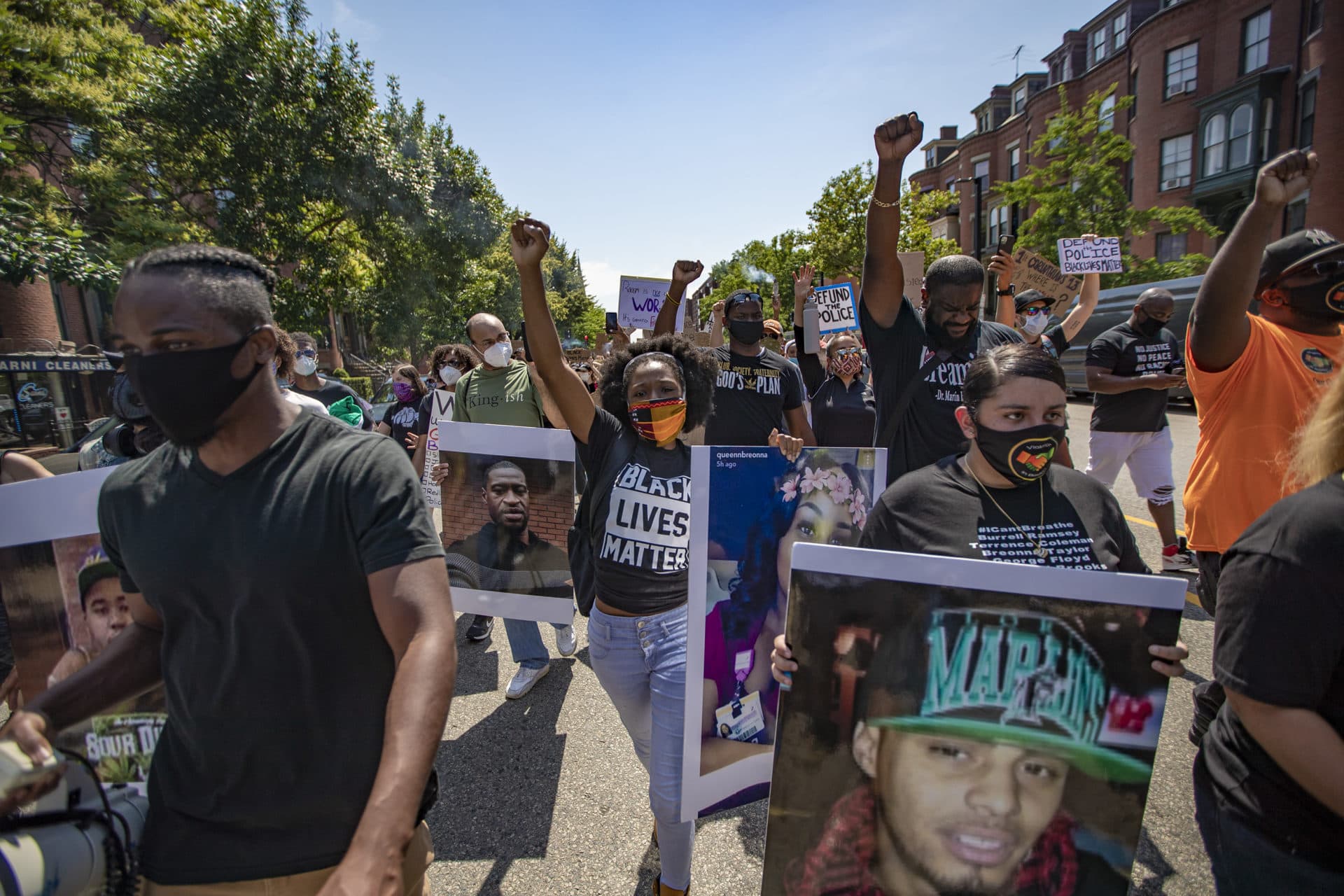 Protesters hold photos of those killed by police, including George Floyd and Breonna Taylor. (Jesse Costa/WBUR)