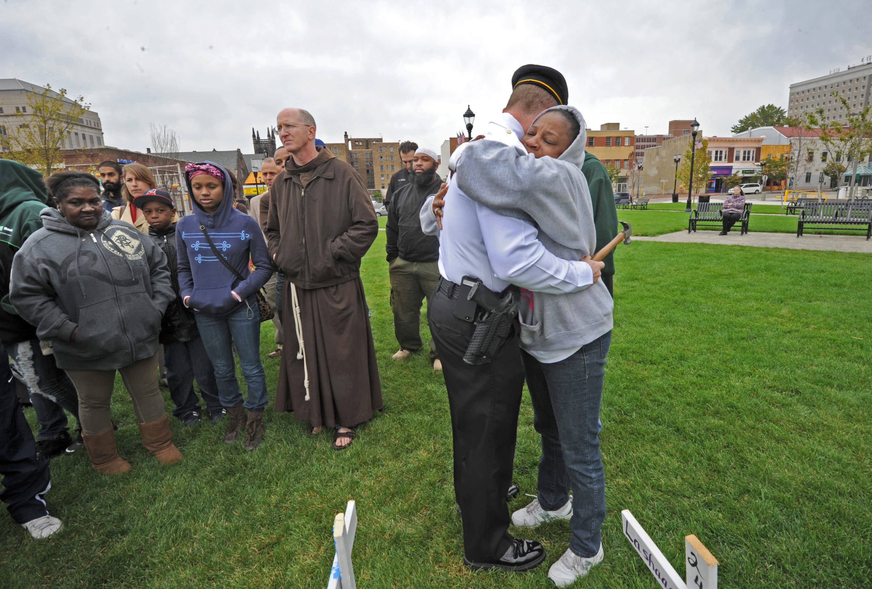 In the field of crosses, mourner Holly Walker gets a hug from Camden Police Chief Scott Thomson. (Photo by April Saul)
