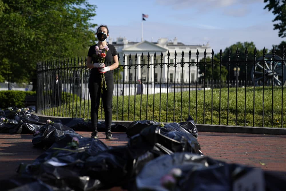 Margot Bloch of Takoma Park, Md., stands in Lafayette Park near the White House as she protests President Donald Trump's handling of the COVID-19 pandemic Wednesday, May 20, 2020, in Washington. She is surrounded by "body bags" representing those who have died. (Evan Vucci/AP)