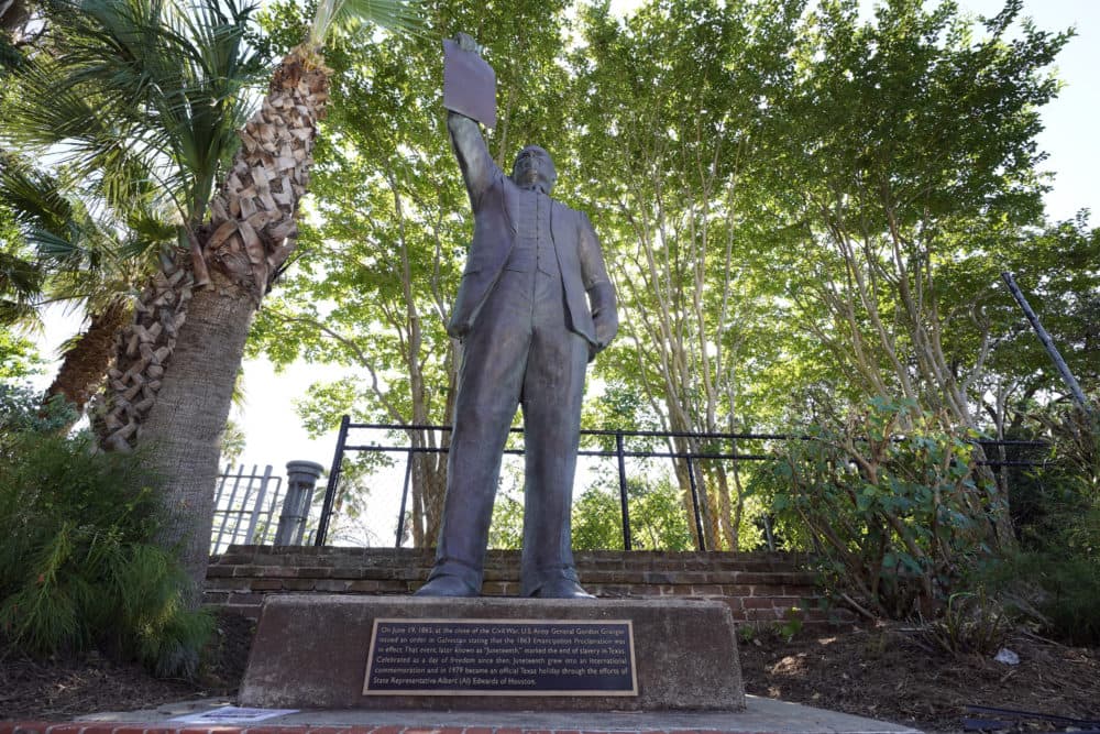 In this June 17, 2020, photo, a statue depicts a man holding the state law that made Juneteenth a state holiday in Galveston, Texas. The inscription on the statue reads "On June 19, 1865, at the close of the Civil War, U.S. Army General Gordon Granger issued an order in Galveston stating that the 1863 Emancipation Proclamation was in effect. That event, later known as "Juneteenth," marked the end of slavery in Texas. Celebrated as a day of freedom since then, Juneteenth grew into an international commemoration and in 1979 became an official Texas holiday through the efforts of State Representative Albert (AL) Edwards of Houston. (David J. Phillip/AP)