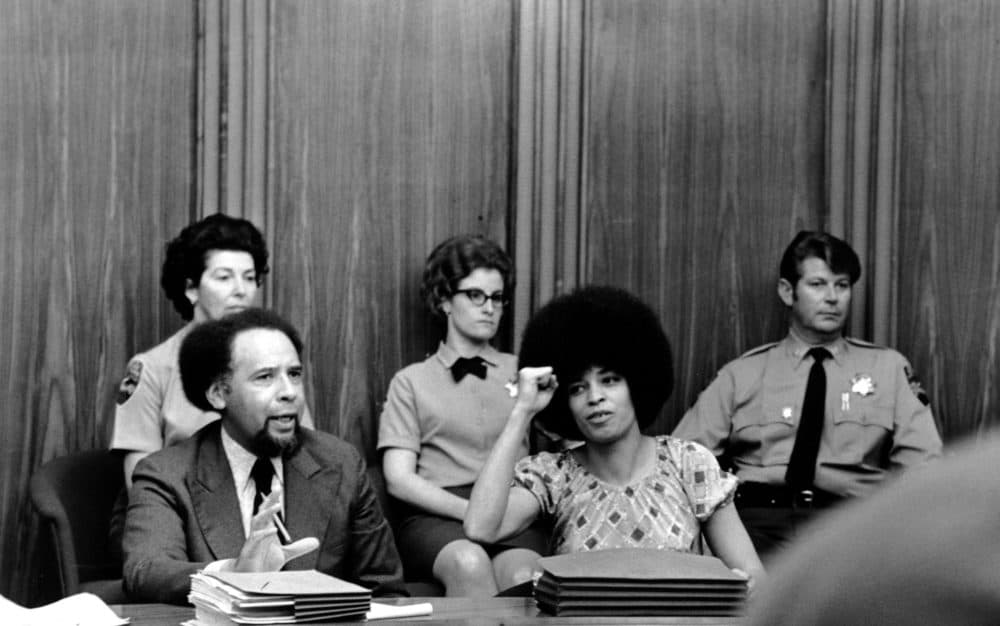 Angela Davis raises her fist to give her power salute as she sits in the courtroom at Marin Civic Center in San Rafael, Ca., on March 16, 1971. (AP Photo)