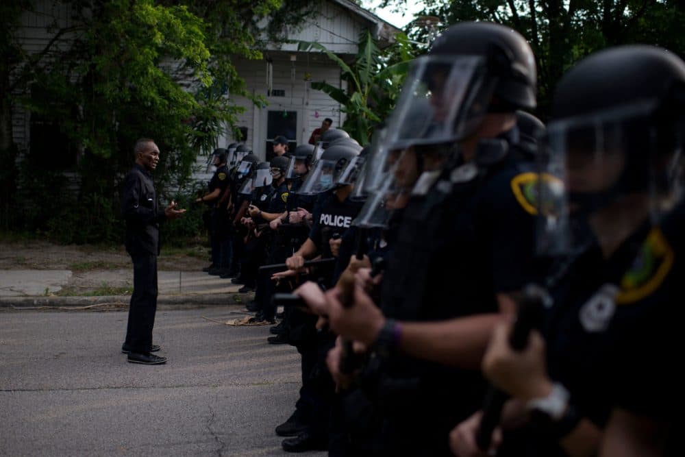A man addresses a row of police officers during a &quot;Justice for George Floyd&quot; event in Houston, Texas on May 30, 2020, after George Floyd, an unarmed black, died while being arrested and pinned to the ground by a Minneapolis police officer. (MARK FELIX/AFP via Getty Images)