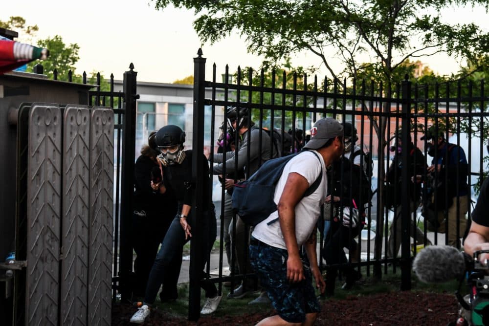Protestors and media personnel run to take cover as police start firing tear gas and rubber bullets near the 5th police precinct following a demonstration to call for justice for George Floyd, a black man who died while in custody of the Minneapolis police, on May 30, 2020 in Minneapolis, Minnesota. (Photo by CHANDAN KHANNA/AFP via Getty Images)