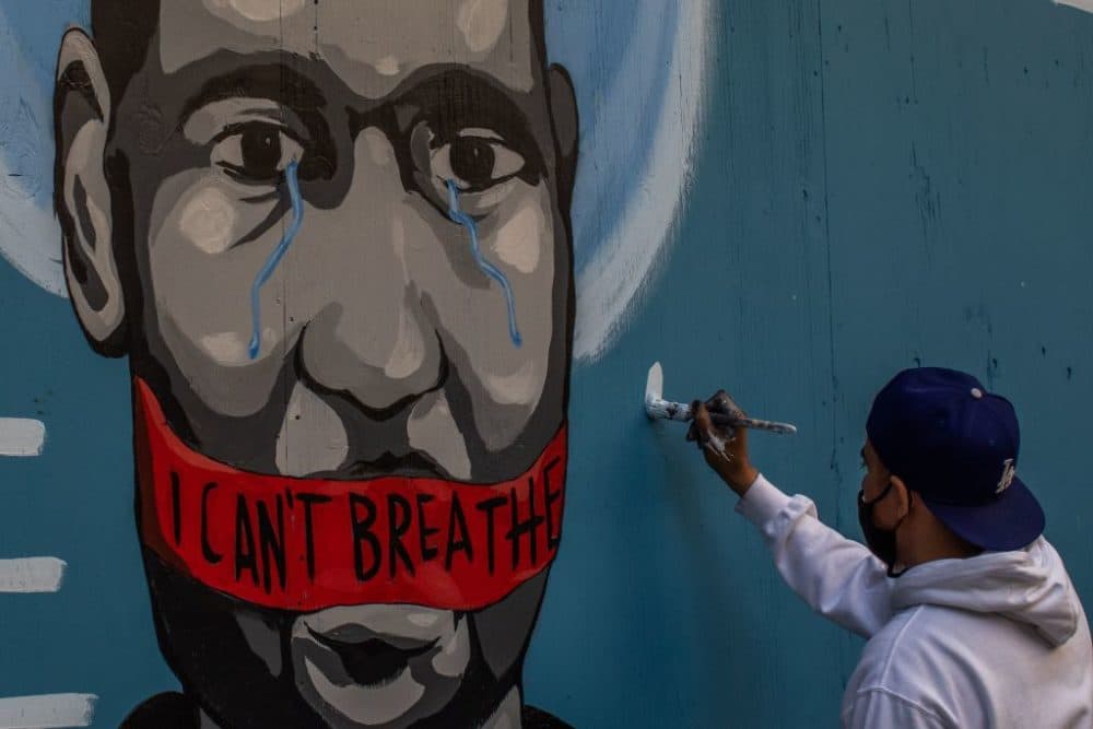 The artist Celos paints a mural in Downtown Los Angeles in protest against the death of George Floyd by police in Minneapolis. (Apu Gomes/AFP/Getty Images)