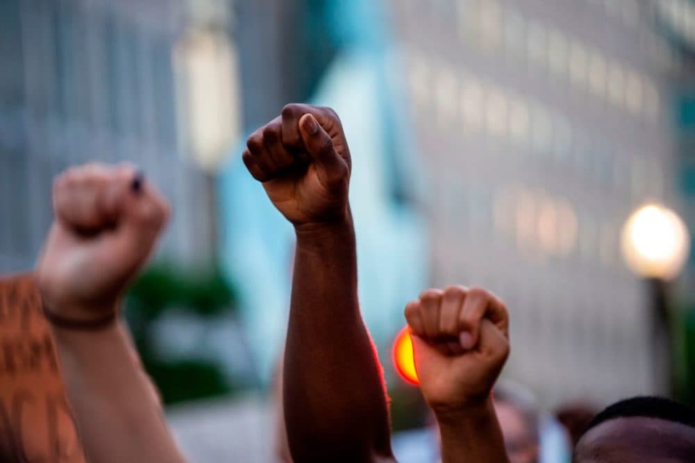 Protesters hold their fists up near a barricade in the vicinity of the White House during protests over the death of George Floyd on June 3, 2020, in Washington, DC. (Roberto Schmidt/AFP/Getty Images)