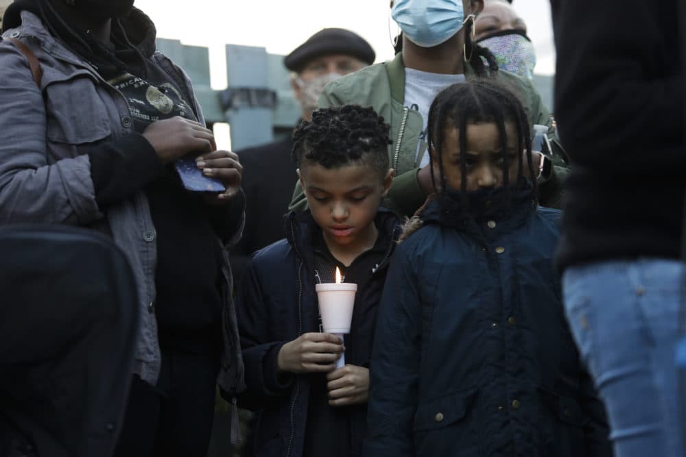 In this June 3, 2020 photo in Tacoma, Washington a boy holds a candle as family, friends and community members attend a vigil at the intersection where Manuel Ellis, a 33-year-old black man, died in Tacoma Police custody on March 3. (Jason Redmond/AFP via Getty Images)
