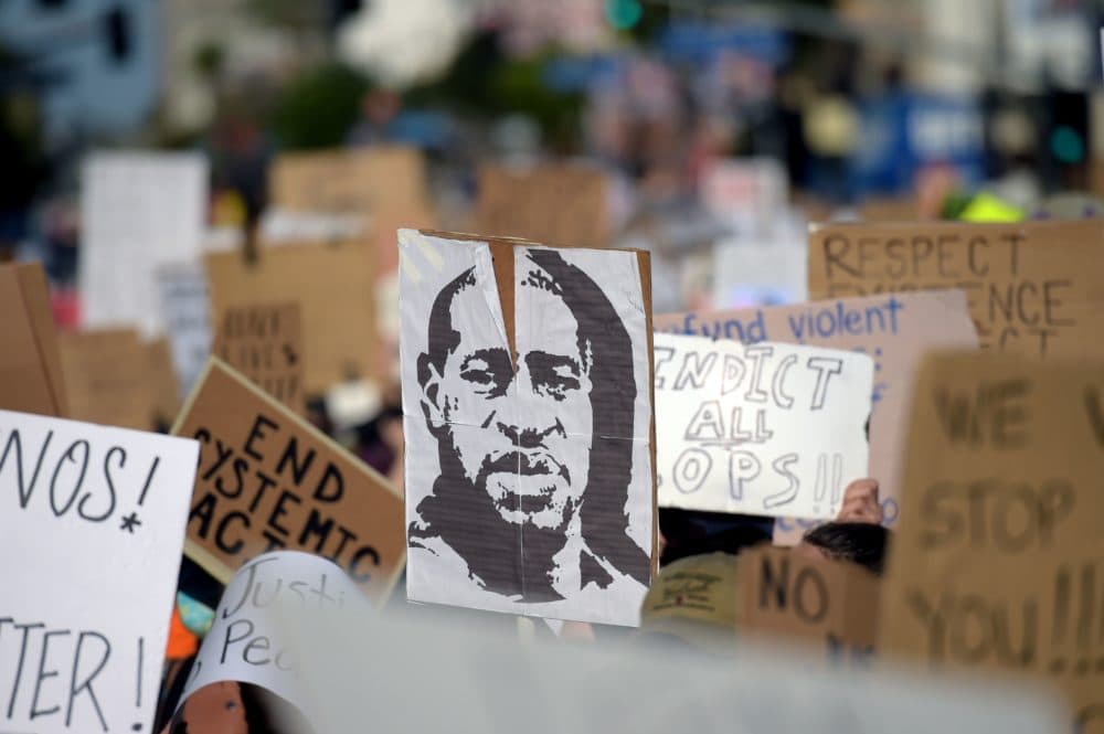 Protesters march holding placards and a portrait of George Floyd during a demonstration against racism and police brutality, in Hollywood, California on June 7, 2020. (Agustin Paullier/ AFP/Getty Images)