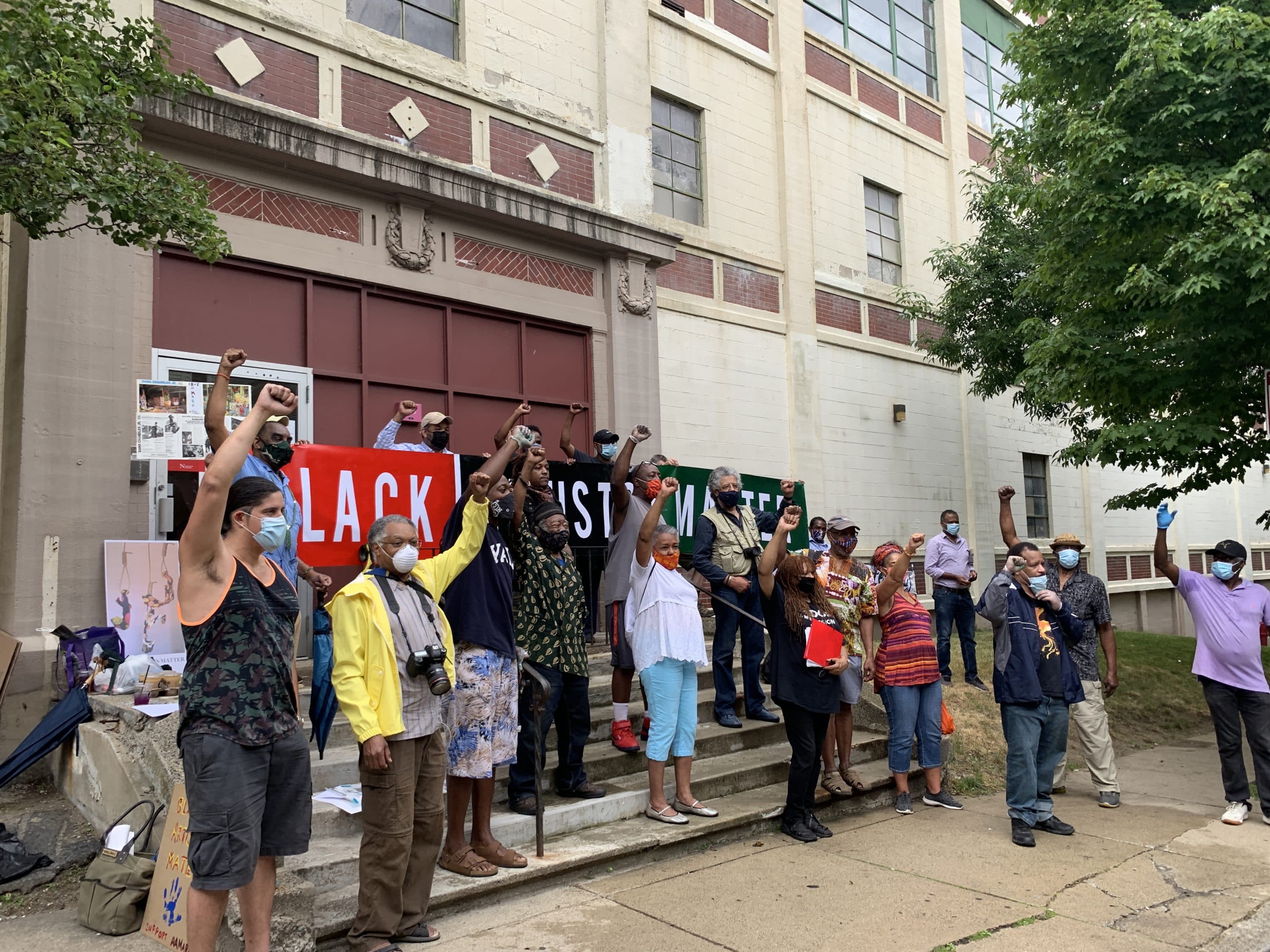 AAMARP artists pose for a photograph in front of their studio space in Jamaica Plain. (Amelia Mason/WBUR)
