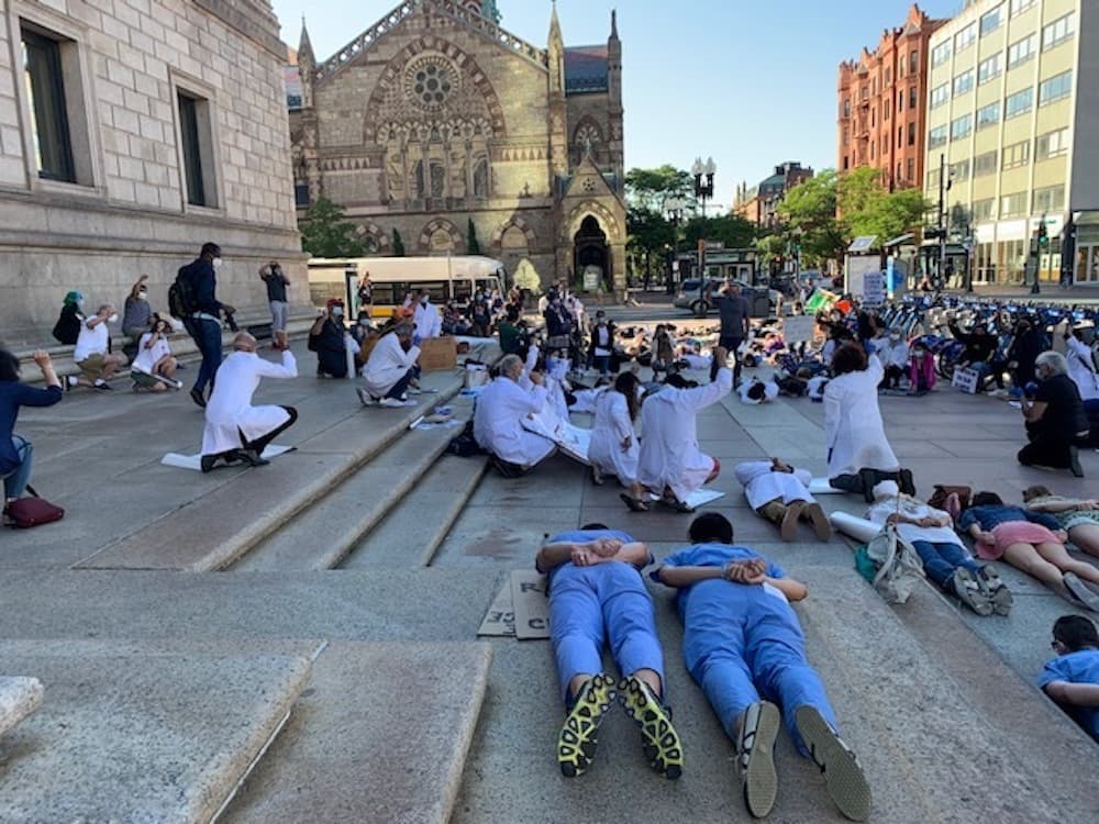 Health care workers participate in a die-in at the ‘White Coats For Black Lives’ rally in Copley Square on Sunday. (Photo courtesy Raabia Malik)