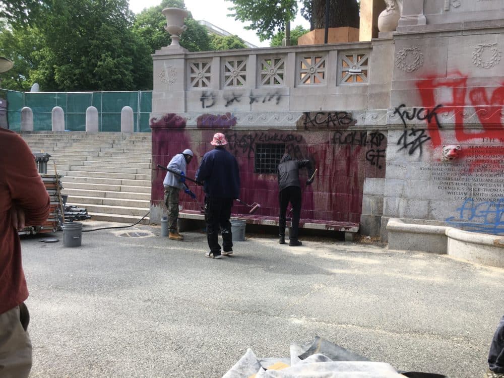 Workers remove graffiti from the backside of the Shaw Memorial. (Courtesy Friends of the Public Garden)