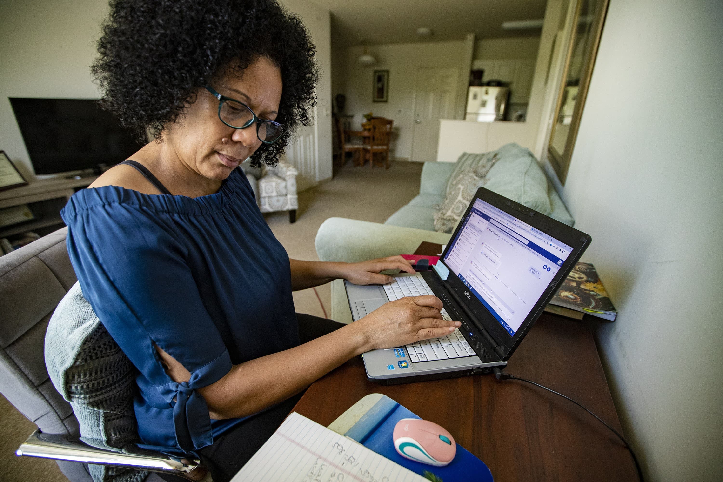 Luisa Schaeffer scrolls through her COVID isolation case list for the day: one woman is out of milk, another needs help finding a doctor and making an appointment. A man asks about help paying his rent. (Jesse Costa/WBUR)