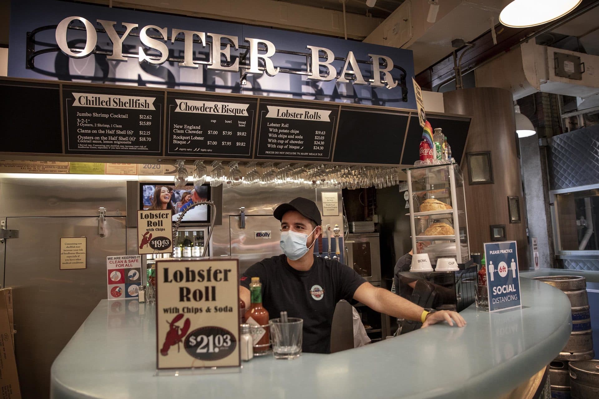 On reopening day at Quincy Market, the Oyster Bar's Paulo Fernandez looks up and down the hall for customers. It's slow, he says, but he's hopeful it will get better through the summer. (Robin Lubbock/WBUR)