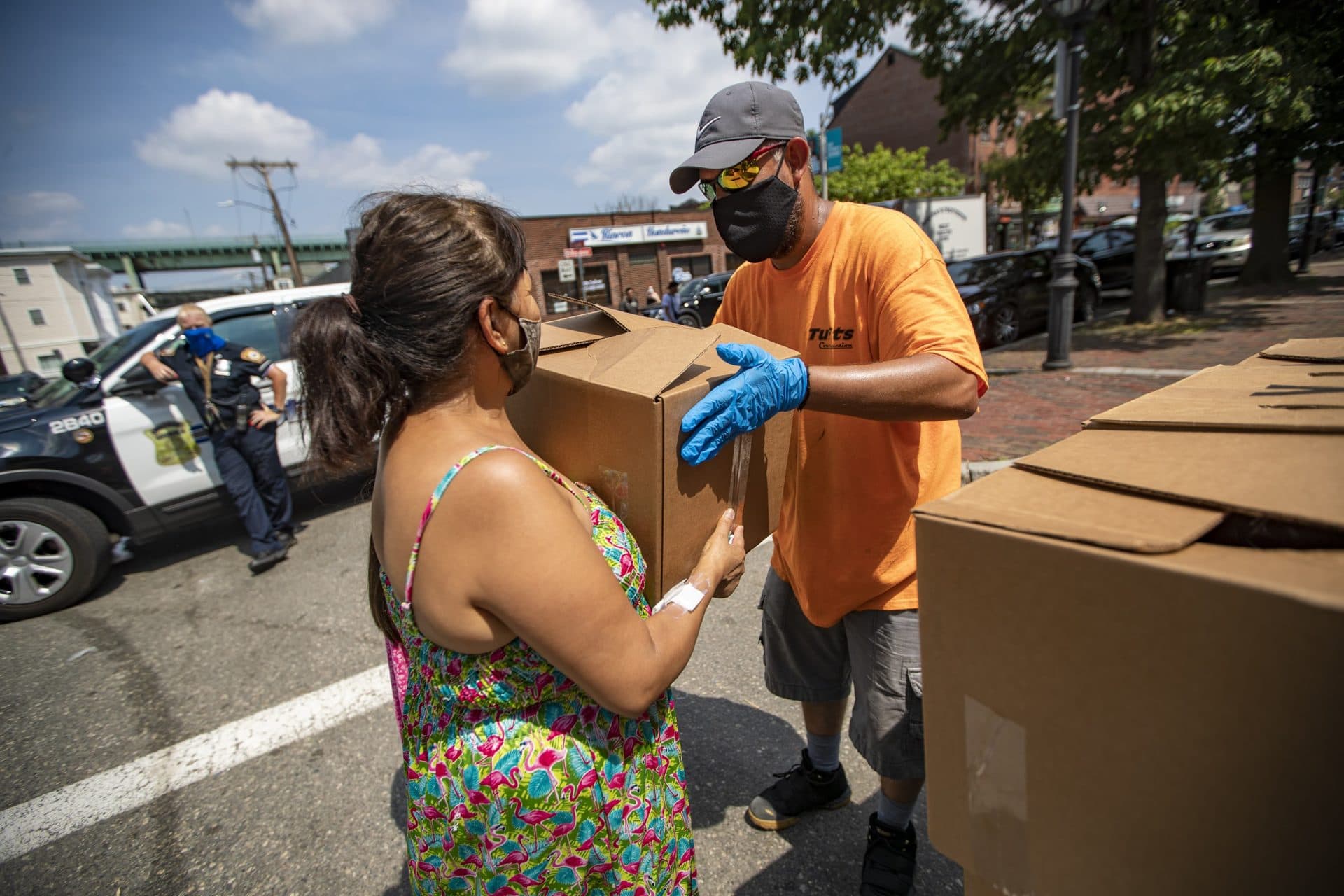 A Chelsea resident receives a box of food supplies at a food pantry in Chelsea Square. (Jesse Costa/WBUR)