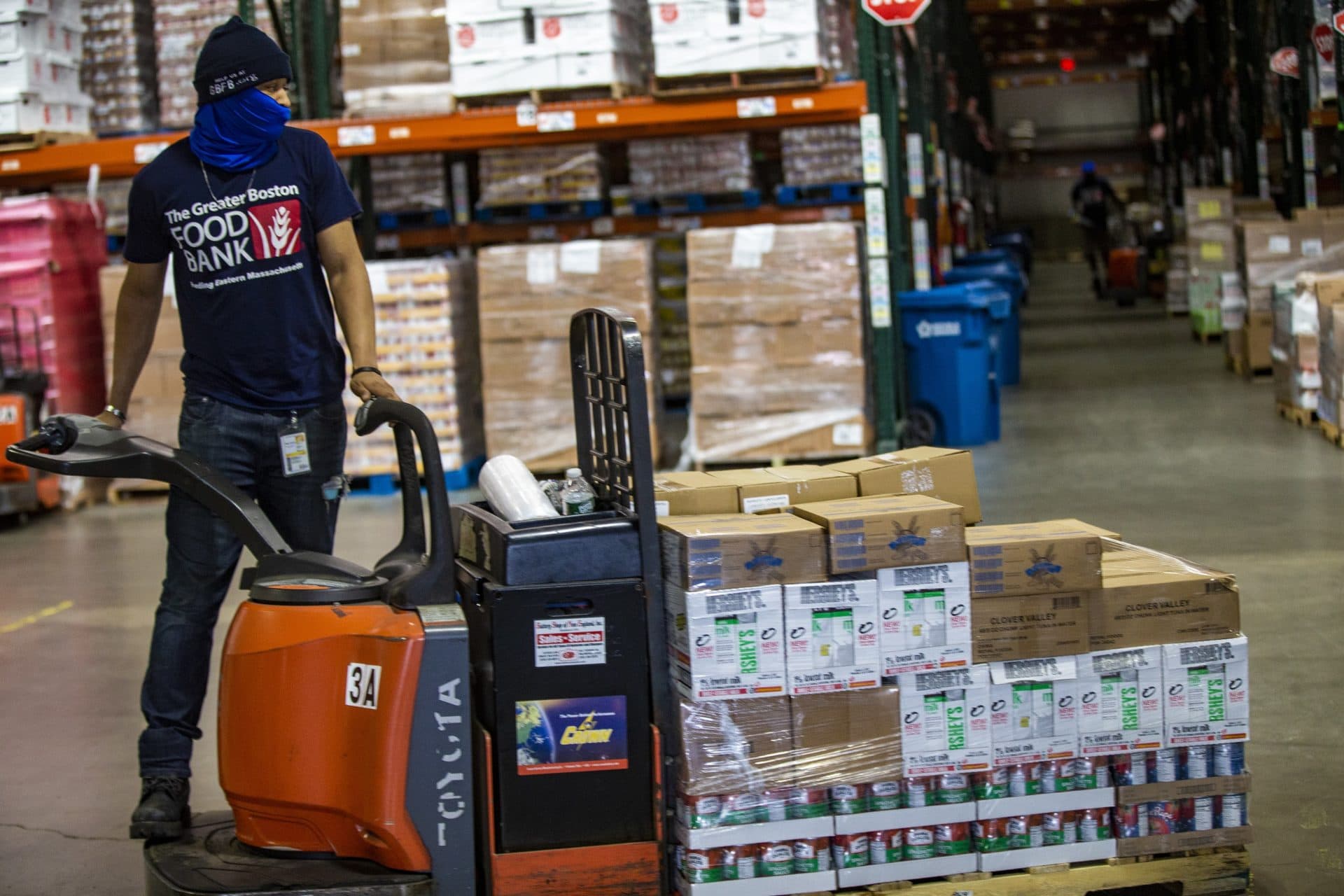 KC Hollis moves a pallet of canned goods to the warehouse door so it may be loaded onto a truck at the Greater Boston Food Bank in Boston. (Jesse Costa/WBUR)