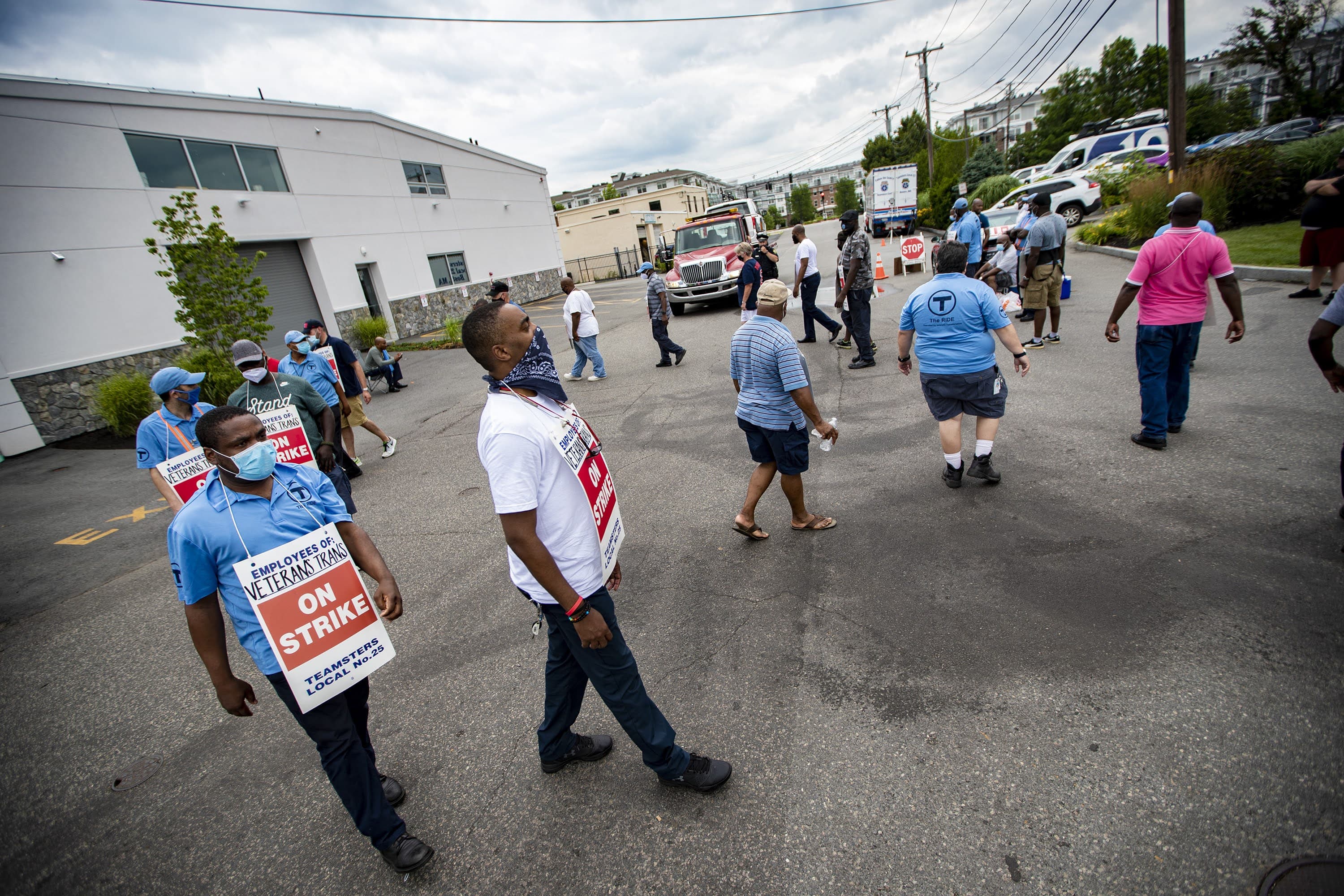 Drivers of Veterans Transportation who operate vehicles for the MBTA’s “The Ride” program, block a tow truck from entering the company garage as they strike outside in Watertown. (Jesse Costa/WBUR)