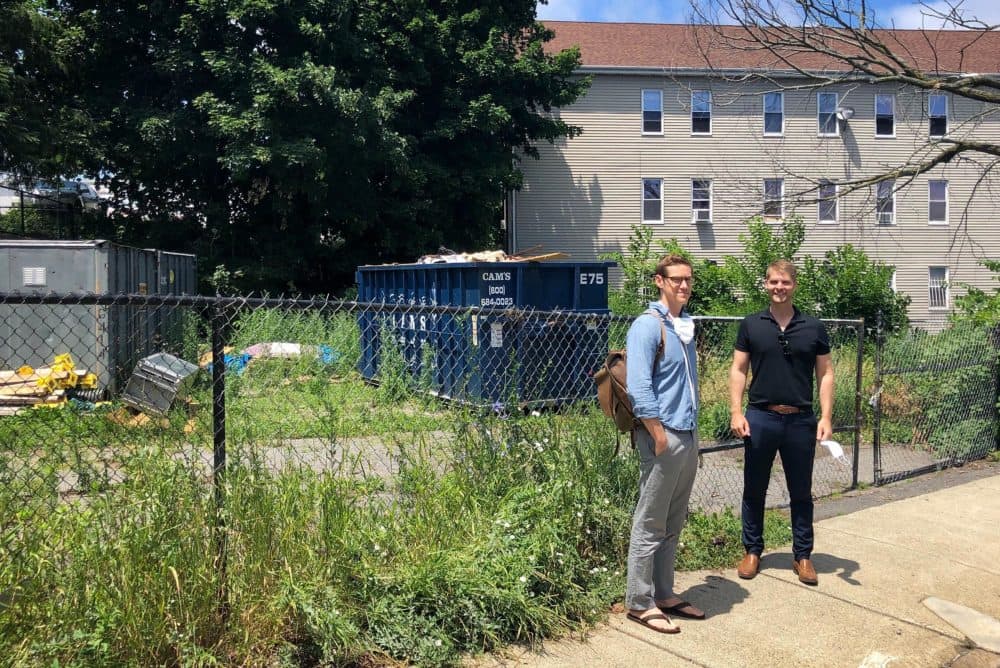 Colin Booth, strategic director at Placetailor, and architect John Klein, CEO of Generate Technologies, stand in front of 201 Hampden St. in Roxbury where they'll be constructing Boston's first building using CLT. (Bruce Gellerman/WBUR)