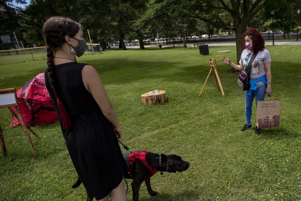 Diana Bernard tells artist Lilly Manycolors how much she has learned after experiencing her installation “The Red Dress Lodge,” on display in the Boston Common. The art installation is meant to bring awareness of murdered and missing indigenous womxn and girls. (Jesse Costa/WBUR)