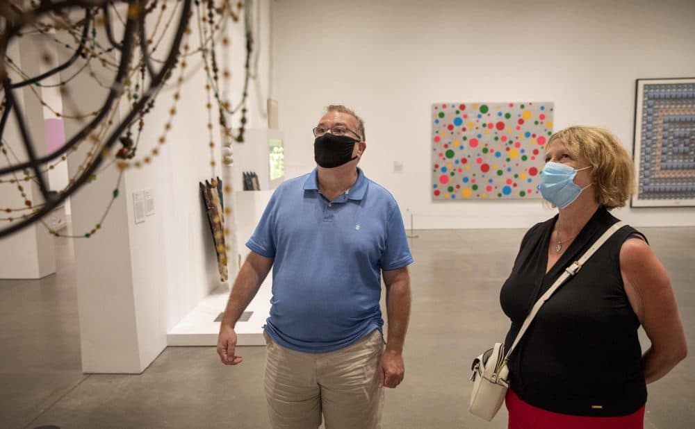 Patrick McAvoy and Theresa Bergstrom, from Boston, look at artist Nick Cave's &quot;Soundsuit&quot; at the ICA. (Robin Lubbock/WBUR)