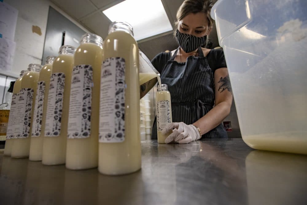 Brit McMahan, manager at Drink in Boston, fills each bottle with piña colada. (Jesse Costa/WBUR)