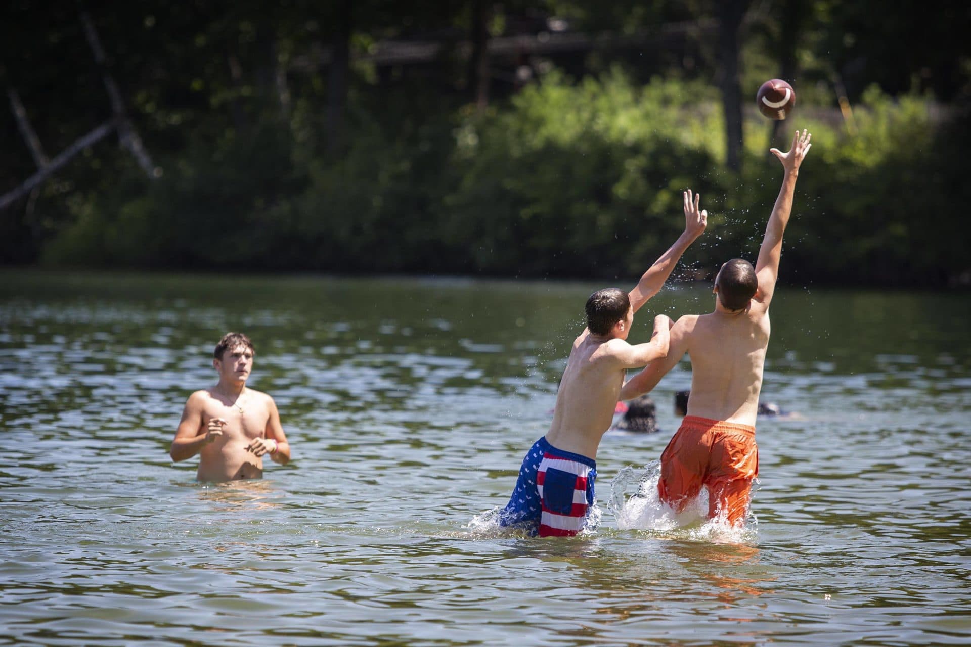 Swimmers cool off with a football at Crystal Lake in Newton. (Robin Lubbock/WBUR)