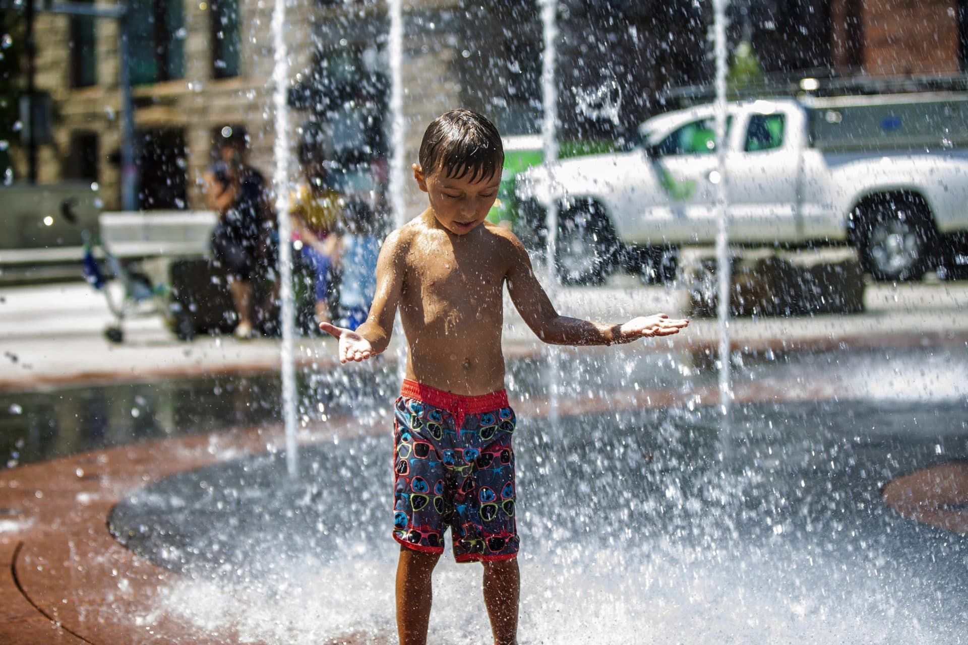 A young boy cools off in the water streams at the Rings Fountain at the Rose Kennedy Greenway. (Jesse Costa/WBUR)