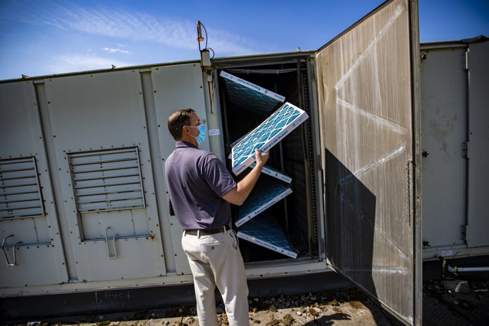 During an inspection at West Somerville NeighborhoodSchool, engineer Scott LeClair pulls out an air filter from an central air conditioning unit that he finds are only 30 percent efficient. They will be upgraded with filters that closer to 95 percent efficient. (Jesse Costa/WBUR)