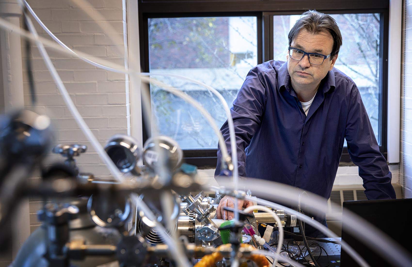 Professor Frank Keutsch looks over the mass spectrometer in his laboratory at Harvard. (Robin Lubbock/WBUR)