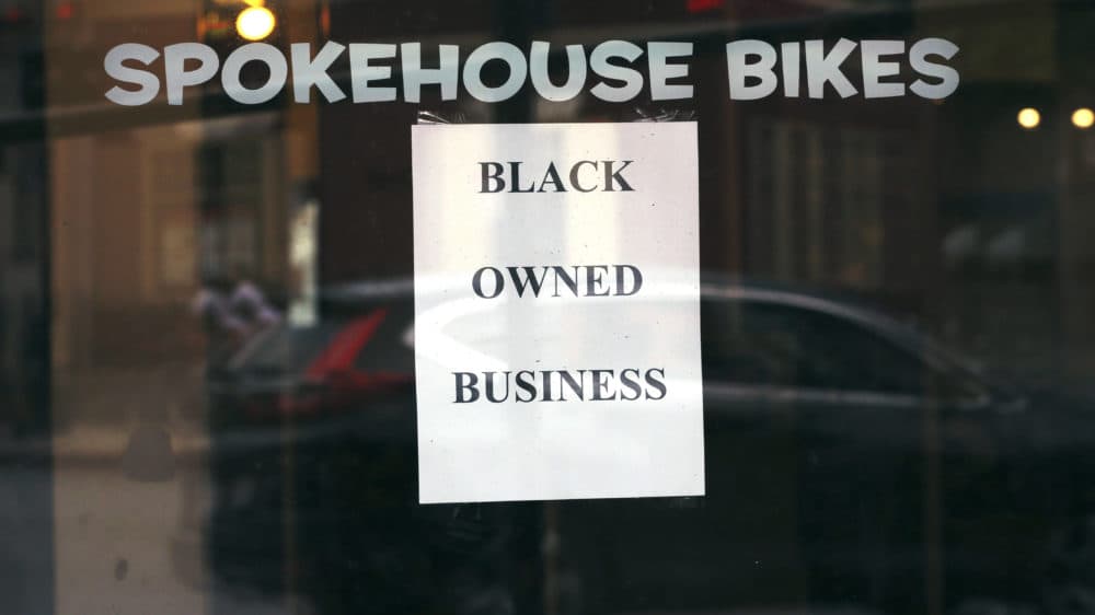 In this June 24, 2020, photograph, a sign in the window informs passersby that Spokehouse Bikes in the Upham's Corner neighborhood of Boston is a Black-owned business. (Charles Krupa/AP)
