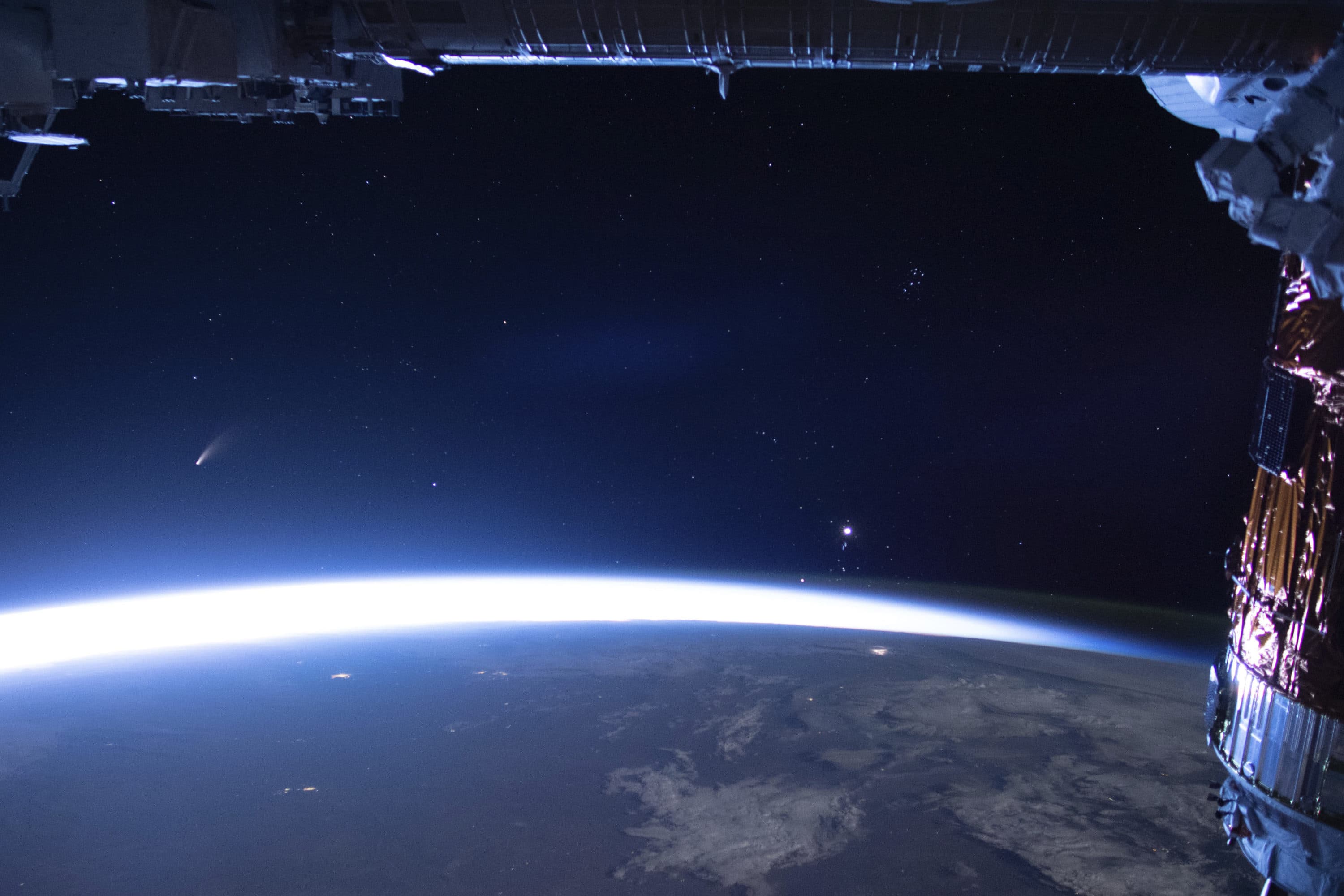 Comet Neowise, left, is seen in the eastern horizon above Earth in this image taken from the International Space Station on Sunday, July 5, 2020. (NASA via AP)