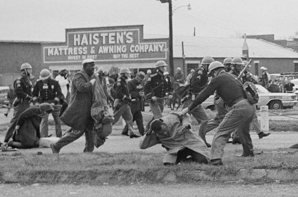 In this March 7, 1965, file photo, a state trooper swings a billy club at John Lewis, right foreground, chairman of the Student Nonviolent Coordinating Committee, to break up a civil rights voting march in Selma, Ala. Lewis sustained a fractured skull. (AP/File)