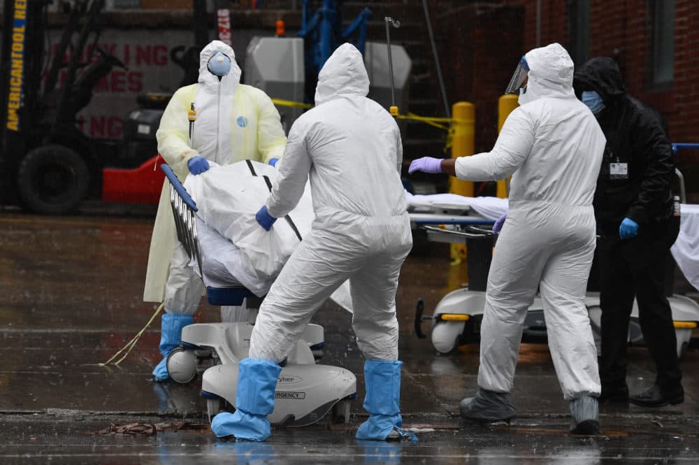 Medical personnel move a deceased patient to a refrigerated truck serving as make shift morgues at Brooklyn Hospital Center on April 09, 2020 in New York City. (Angela Weiss/AFP via Getty Images)