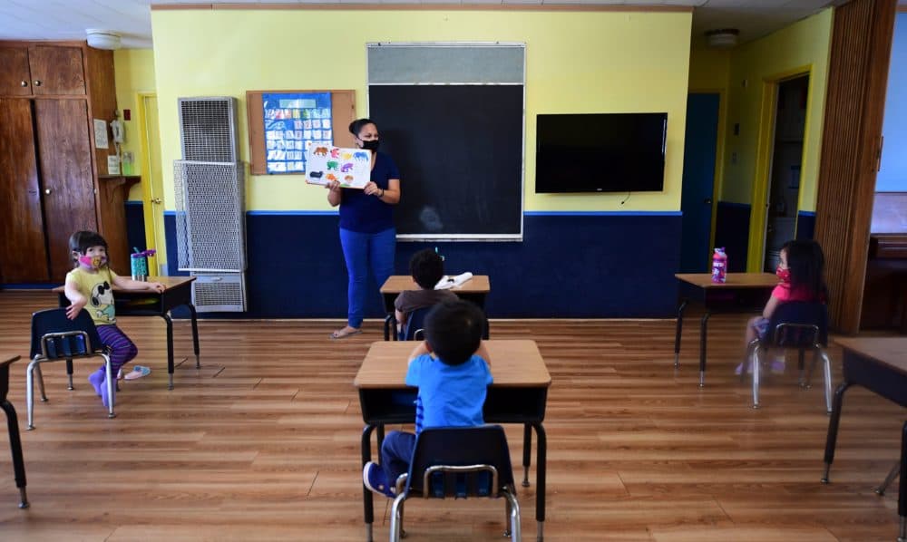 Instructor Chablis Torres (C) reads to children in a pre-school class, wearing masks and at desks spaced apart as per coronavirus guidelines during summer school sessions in Monterey Park, California on July 9, 2020. (Frederic J. Brown/AFP via Getty Images)