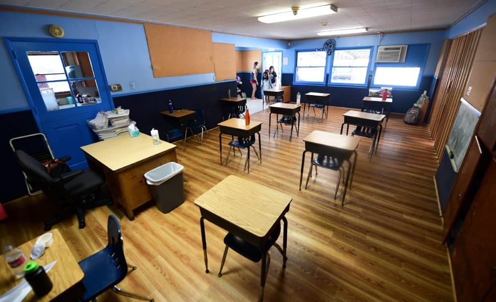 Children in an elementary school class wearing masks enter the classroom with desks spaced apart as per coronavirus guidelines during summer school sessions in Monterey Park, California. (Frederic J. Brown/AFP/Getty Images)