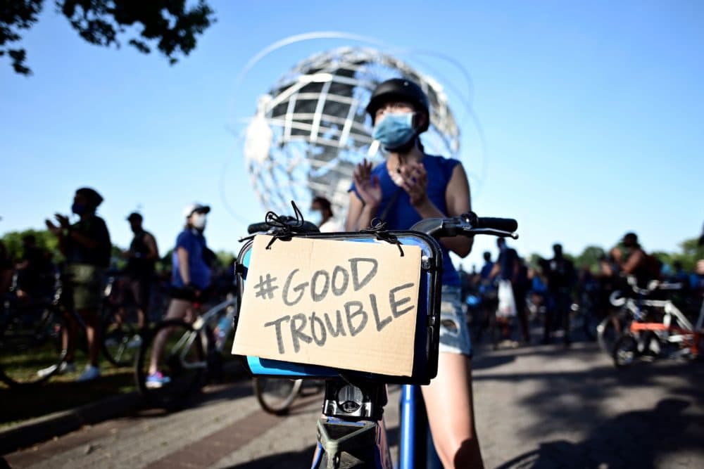 A protestor displays a sign that read #Good Trouble, in homage to recently deceased Congressman and activist John Lewis during a Justice Ride, supporting the Black Lives Matter movement on July 18, 2020 in the Flushing Meadows-Corona Park in the borough of Queens, New York City. (Johannes Eisele/AFP)