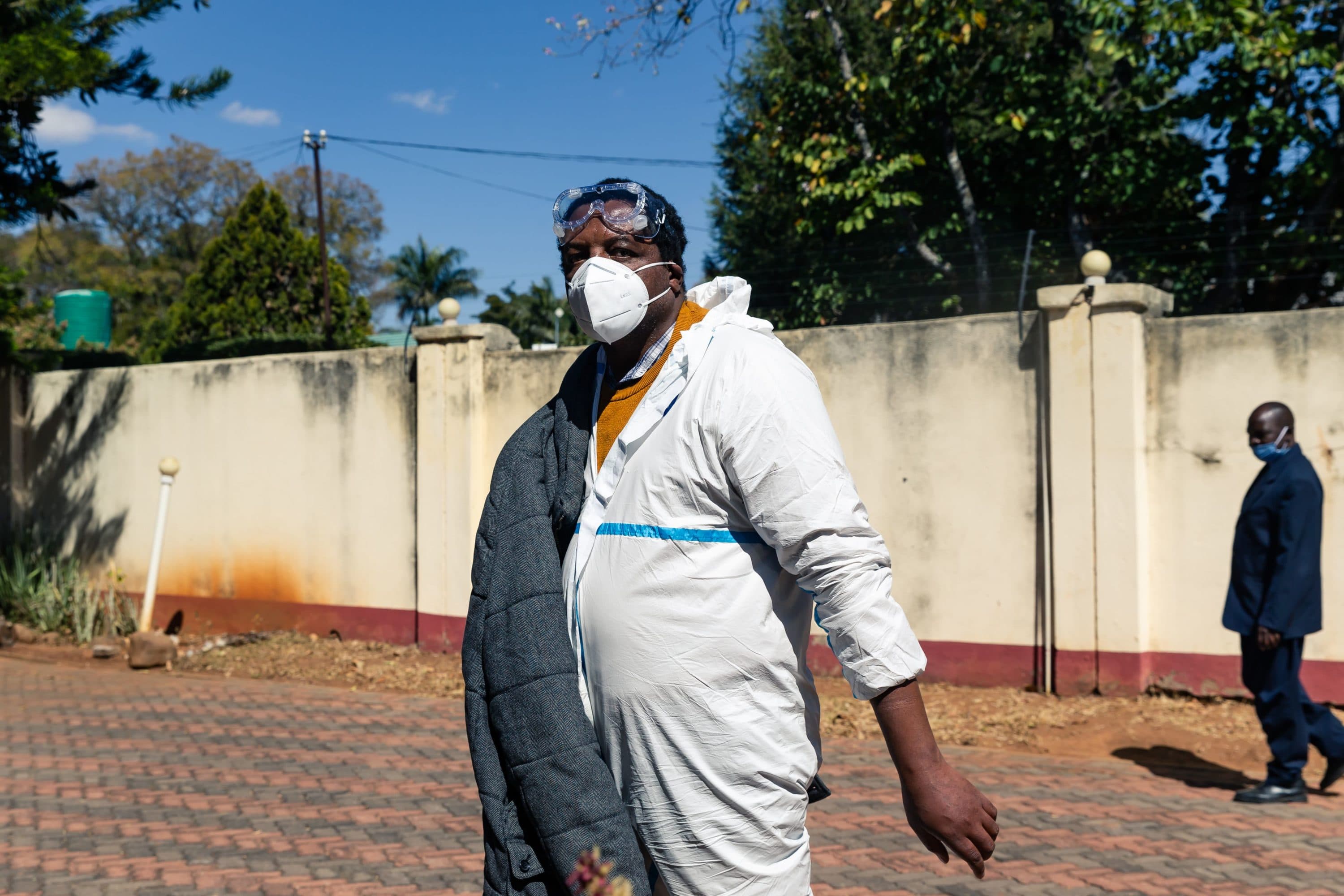 Zimbabwean journalist and documentary filmmaker Hopewell Chin'ono arrives at his home in police custody as police conduct a search of his offices in Harare on July 21, 2020, a day after he was arrested and charged with incitement to commit public violence. - Chin'ono and opposition politician Jacob Ngarivhume were the latest among several of President Emmerson Mnangagwa's critics to be arrested or have their homes raided and searched ahead of protests planned for July 31, 2020, with the aim to denounce state corruption. (Jekesai Njikizana/AFP via Getty Images)