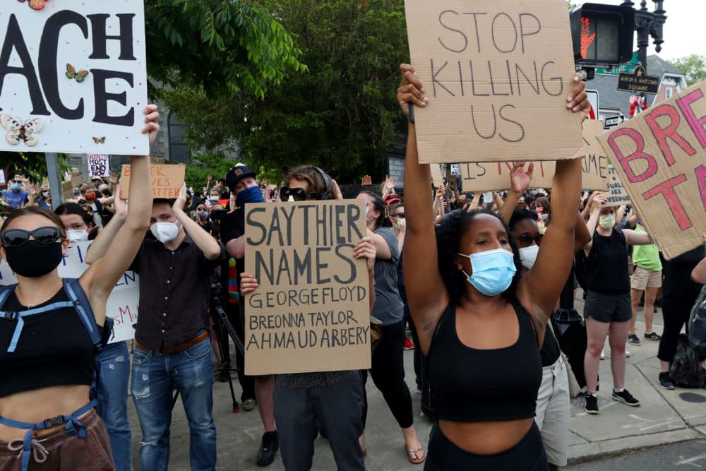 Protesters hold signs during a protest in the Jamaica Plain neighborhood on June 04, 2020 in Boston. (Maddie Meyer/Getty Images)