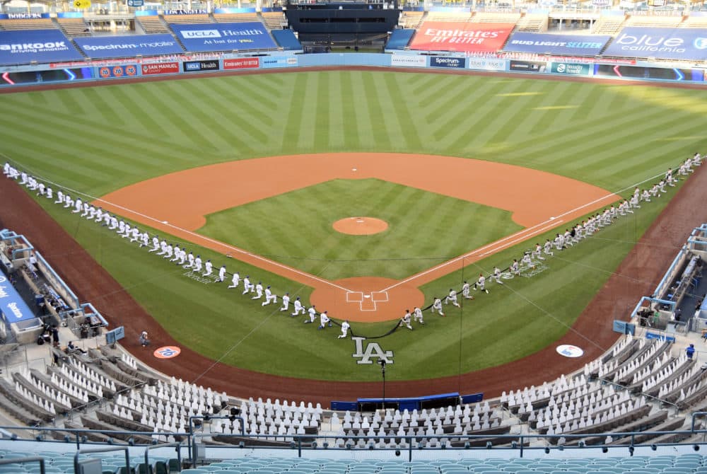 Members of the Los Angeles Dodgers and the San Francisco Giants kneel prior to the national anthem before their game at Dodger Stadium on July 23, 2020 in Los Angeles, California. (Harry How/Getty Images)