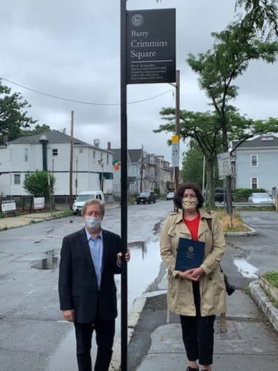 Jimmy Tingle and Helen Crimmins under the plaque commemorating Barry Crimmins Square in Cambridge's Inman Square. (Courtesy)