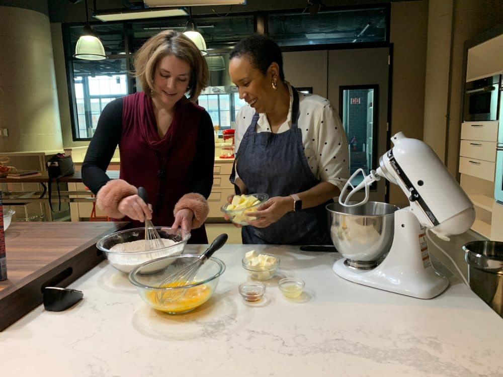 Tiziana Dearing and Elle Simone Scott work on mixing together ingredients for lemon pound cake. (Zoë Mitchell/WBUR)