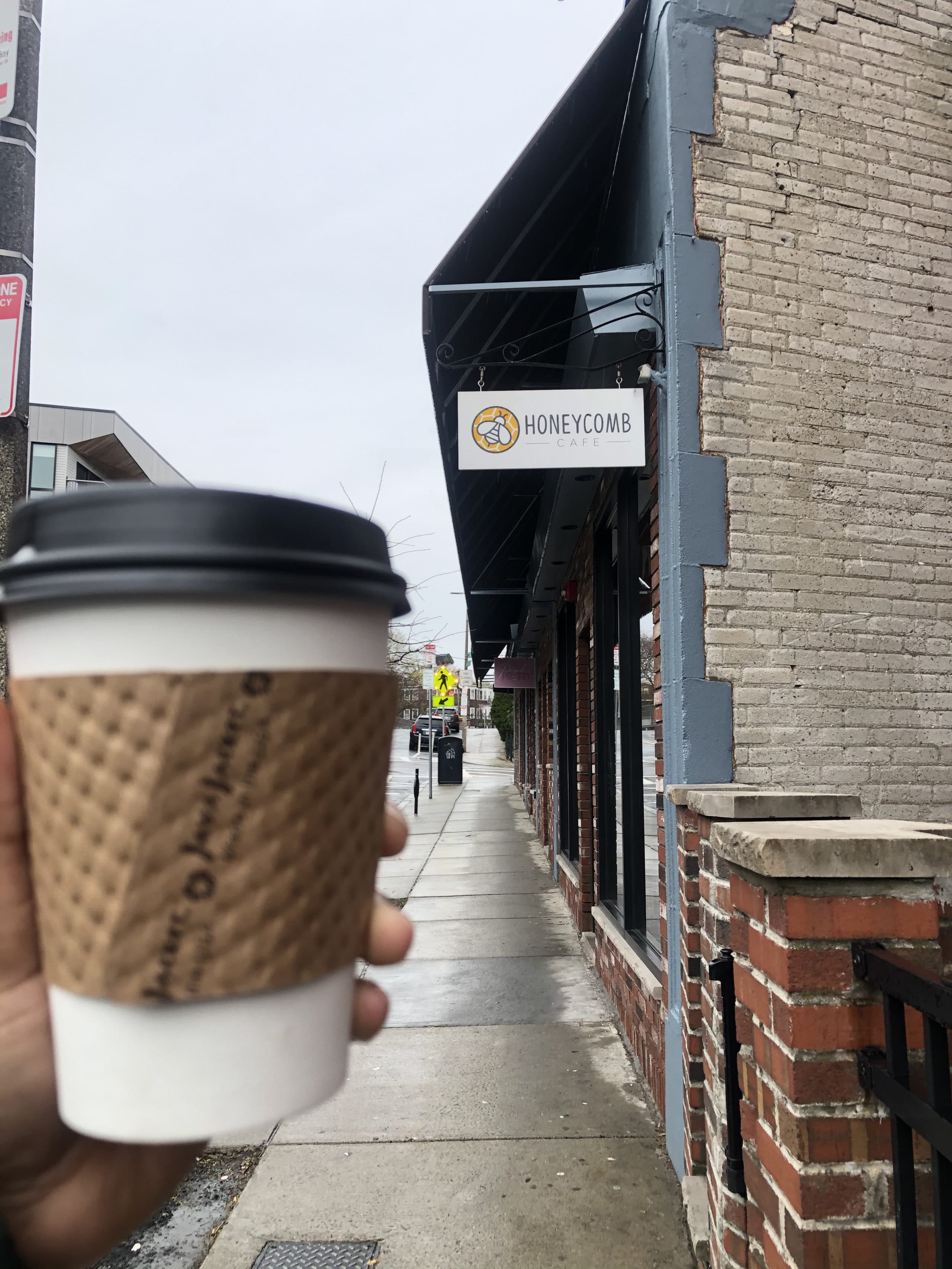 Christian holds up a cup of coffee from one of her favorite local shops, Honeycomb Cafe in Dorchester.