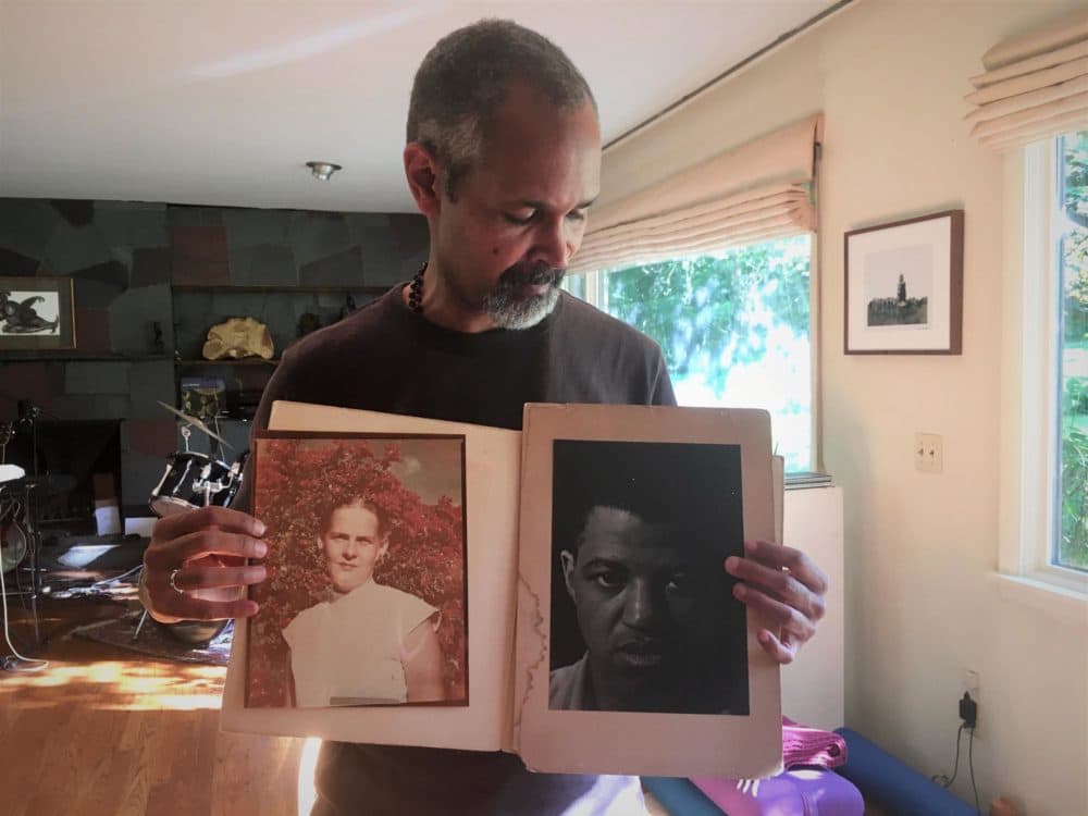 Yawu Miller holds photos of his grandparents, Amelie and John Bates. (Anna Van Dine/VPR)