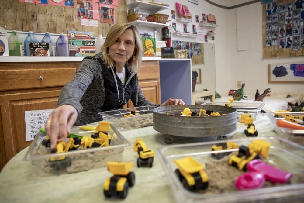 Reed Donahue, the owner of the Little Red Wagon Playschool, arranges toys at the school back in April. (Robin Lubbock/WBUR)