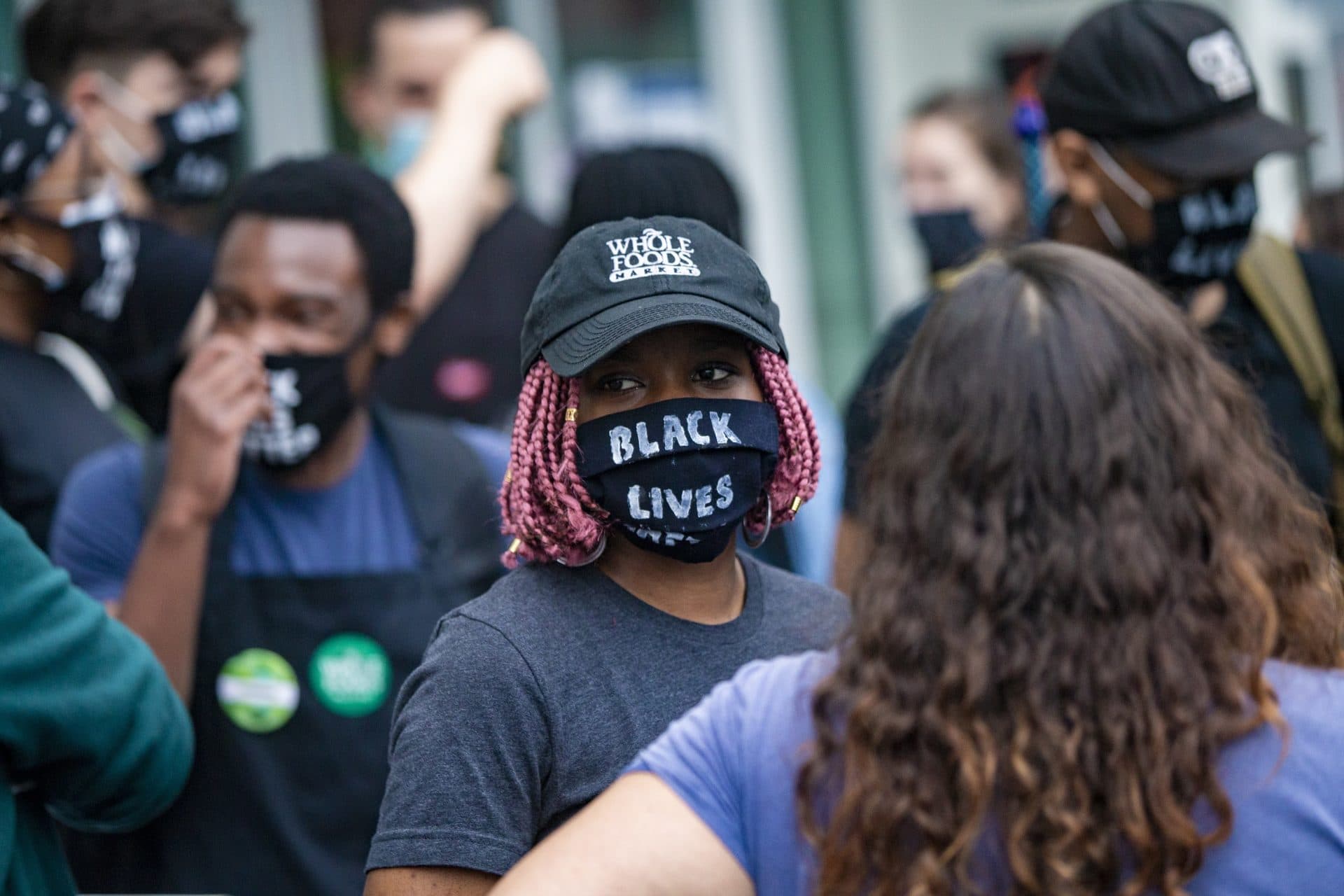 A group of Whole Foods employees dismissed by managers for wearing Black Lives Matter masks during their shifts gather outside of the Whole Foods on River Street in Cambridge. (Jesse Costa/WBUR)